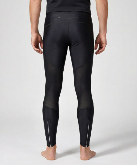 Manlig modell visar ett par svarta långa tights. Modellen står framifrån i en studio med ljusgrå bakgrund.