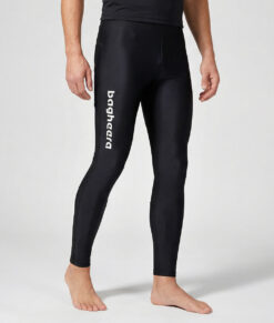 Manlig modell visar ett par svarta långa tights. Modellen står framifrån i en studio med ljusgrå bakgrund.