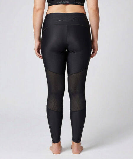 Kvinnlig modell visar ett par svarta race tights. Modellen står bakifrån i en studio med ljusgrå bakgrund.