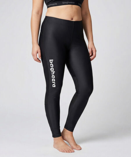 Kvinnlig modell visar ett par svarta race tights. Modellen står framifrån i en studio med ljusgrå bakgrund.