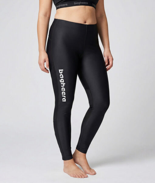 Kvinnlig modell visar ett par svarta race tights. Modellen står framifrån i en studio med ljusgrå bakgrund.