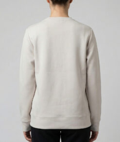 Kvinlig modell visar vår sandfärgade unisex Cloud Crew Neck tröja bakifrån mot en ljusgrå bakgrund.