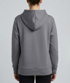 Kvinlig modell visar vår mörkgrå huvjacka i unisexmodell. Cloud Crew Neck bakifrån mot en ljusgrå bakgrund.