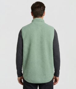 Manlig modell visar vår ljusgröna Comfy Vest bakifrån mot en ljusgrå bakgrund.