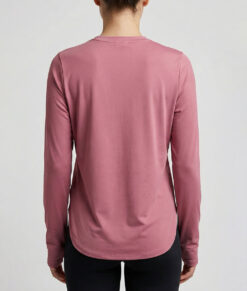 Kvinlig modell visar en rosefärgad långärmad träningströja Serene Tank Top för dam. Modellen visar tröjan bakifrån mot en ljusgrå bakgrund.