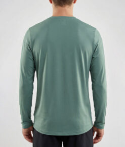 Manlig modell visar en mörkgrön långärmad träningströja Serene LS Top för herr. Modellen visar tröjan bakifrån mot en ljusgrå bakgrund.