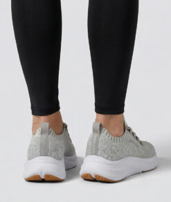 Kvinlig modell visar en sandfärgad bagheera phoenix sneaker. Modellen står bakifrån i en studio med ljusgrå bakgrund.