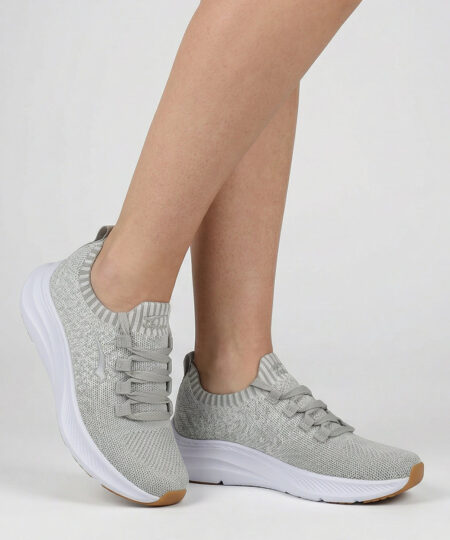 Kvinlig modell visar en sandfärgad bagheera phoenix sneaker. Modellen står framifrån i en studio med ljusgrå bakgrund.