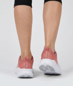 Kvinlig modell visar en vit rosa bagheera sigma sneaker. Modellen står bakifrån i en studio med ljusgrå bakgrund.
