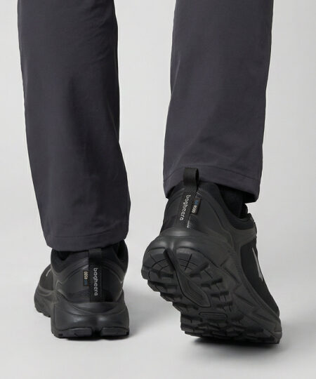 Manlig modell visar en svart bagheera walker promenadsko. Modellen står bakifrån i en studio med ljusgrå bakgrund.