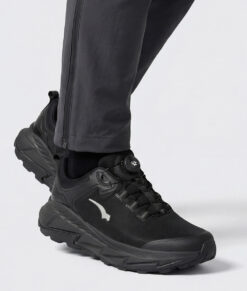 Male model showing off a black bagheera walker walking shoe. The model is standing diagonally from the front in a studio with a light gray background.