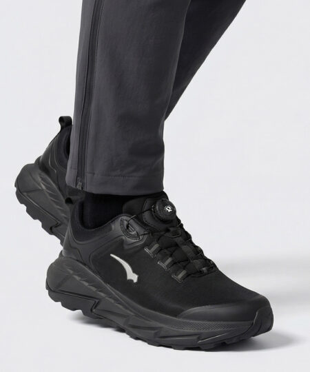 Manlig modell visar en svart bagheera walker promenadsko. Modellen står snett framifrån i en studio med ljusgrå bakgrund.