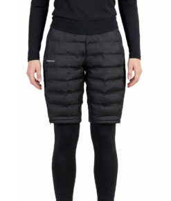 Kvinlig modell visar ett par svarta vadderade shorts med dragkedja i dammodell. Modellen har på sig ett svart underställ och står i en studio med ljusgrå bakgrund framifrån.