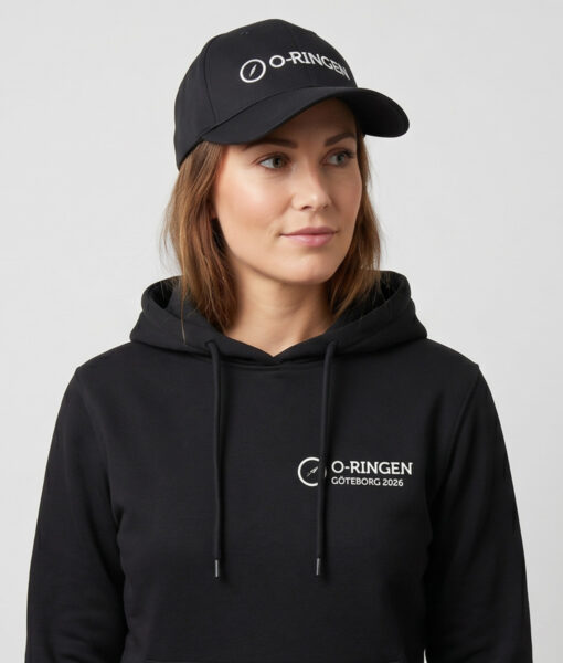 Kvinlig modell visar en svart keps med o-ringen logo. Modellen har på sig en svart o-ringen göteborg 2026 hoodie framifrån i en studio med grå bakgrund.