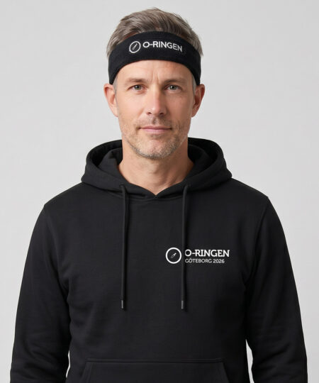 Manlig modell visar ett svart klassiskt frotépannaband med o-ringen logo. Modellen har på sig en svart o-ringen göteborg 2026 hoodie framifrån i en studio med grå bakgrund.