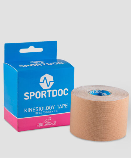 En rulle beige Sportdoc kinesiology sporttape visas framför den tillhörande förpackningen. Tapen visas mot ljusgrå bakgrund.