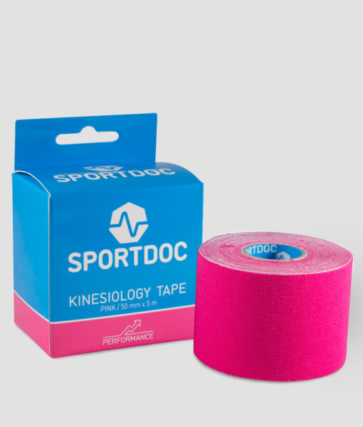 En rulle rosa Sportdoc kinesiology sporttape visas framför den tillhörande förpackningen. Tapen visas mot ljusgrå bakgrund.