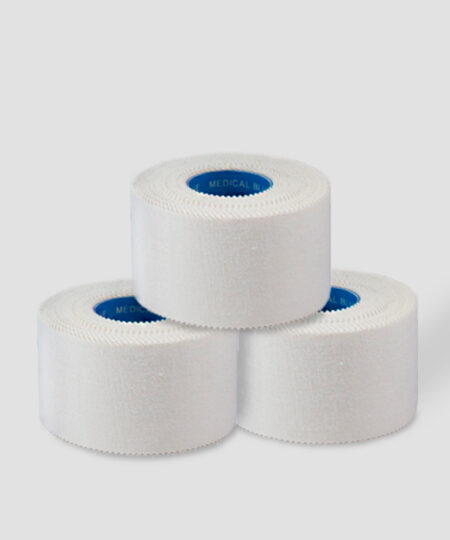 Tre rullar vit Sportdoc medical blue 38mm sporttape. Tapen visas snett från sidan mot ljusgrå bakgrund.