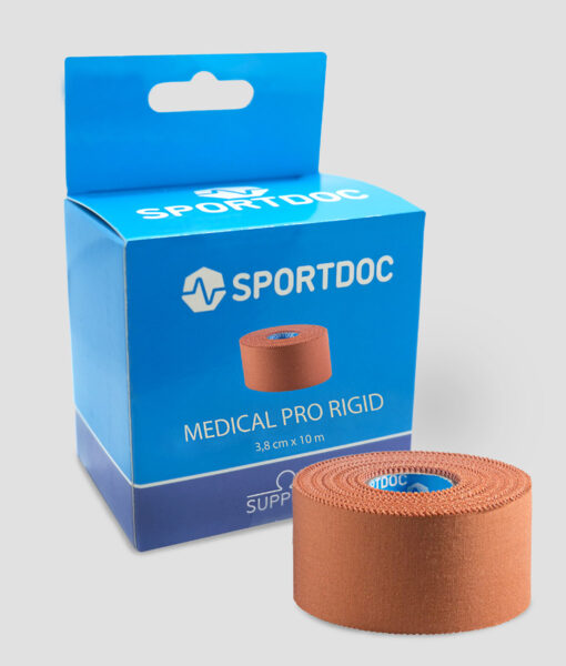En rulle beige Sportdoc medical pro rigid sporttape visas framför den tillhörande förpackningen. Tapen visas mot ljusgrå bakgrund.
