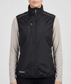 Kvinlig modell visar en svart fleece väst Modellen visar västen framifrån i en studio med ljusgrå bakgrund.