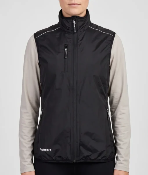 Kvinlig modell visar en svart fleece väst Modellen visar västen framifrån i en studio med ljusgrå bakgrund.
