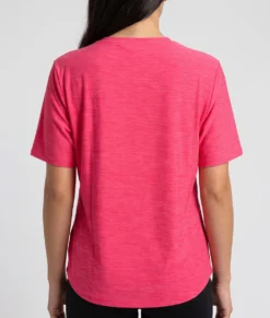 Kvinlig modell visar en ceriserosa Melange tränings t-shirt med lös passform. Modellen visar t-shirten bakifrån i en studio med ljusgrå bakgrund.