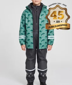Pojkmodell visar en dimblå fleecefodrad regnjacka och svarta regnbyxor i ett paketpris. Modellen står framifrån i en studio med ljusgrå bakgrund.