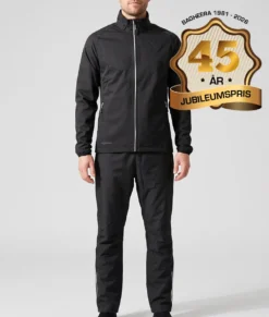 Manlig modell visar Selva svart jacka och svarta byxor i ett paketpris. Modellen står framifrån i en studio med ljusgrå bakgrund.