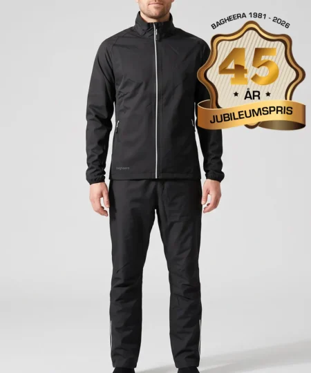 Manlig modell visar Selva svart jacka och svarta byxor i ett paketpris. Modellen står framifrån i en studio med ljusgrå bakgrund.